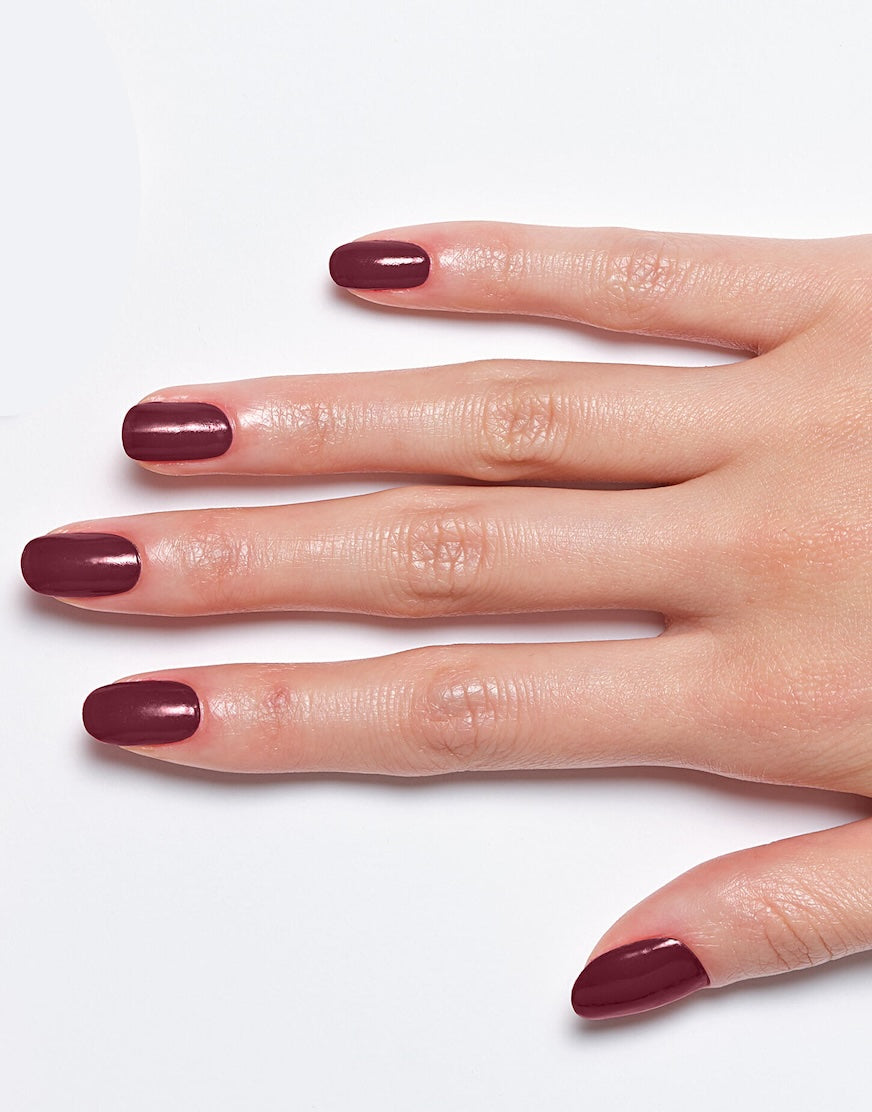 Models' hand showcasing Sally Hansen Miracle Gel Supercharged Bold Glam in Downtown Rush 490, a deep wine creme nail colour