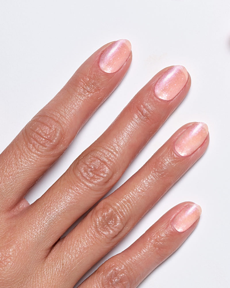 Model's hand showcasing Miracle Gel Tough Love nail polish with a soft pink shimmer.